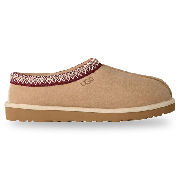 Tan UGG slipper with a white sole on a white background