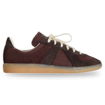 Brown sneaker with white laces on a light gray background - Image 1