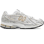 White athletic shoe with gold accents on a white background - Image 1