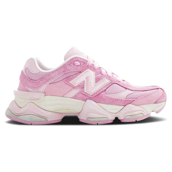 A pair of New Balance 9060 pink overdye sneakers with a mesh upper and a rubber sole.